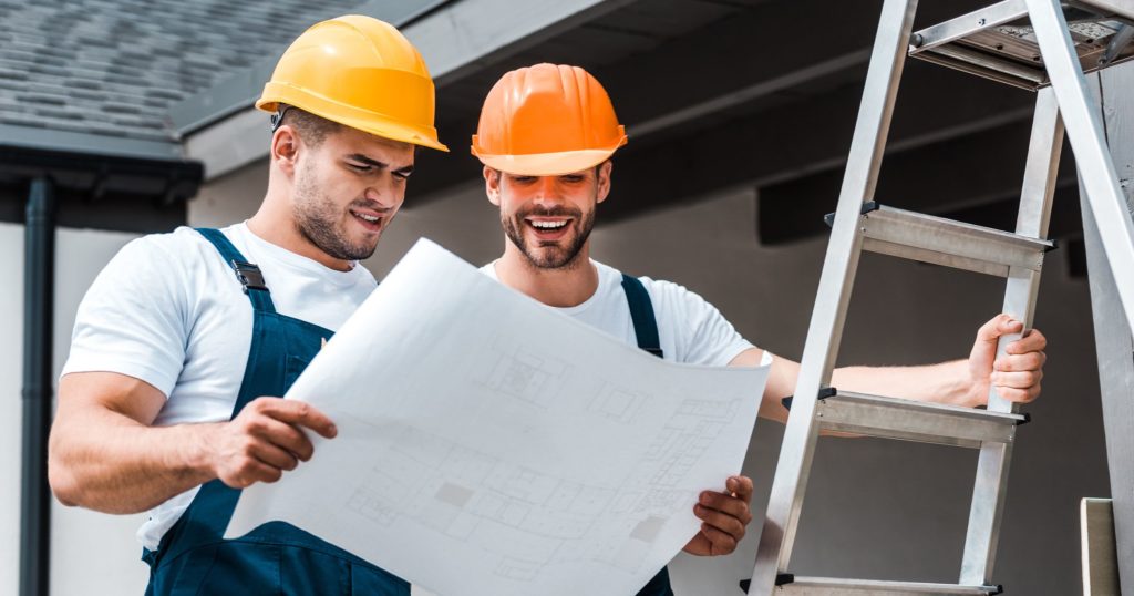 Employees discussing proper ladder usage.